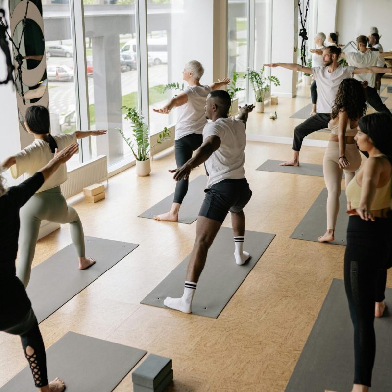 A diverse group of adults practicing yoga indoors, promoting wellness and mindfulness.